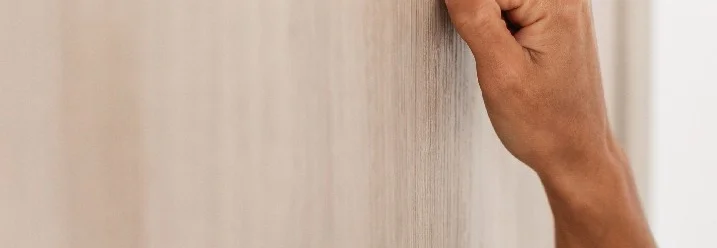 Person klopft an Holzwand